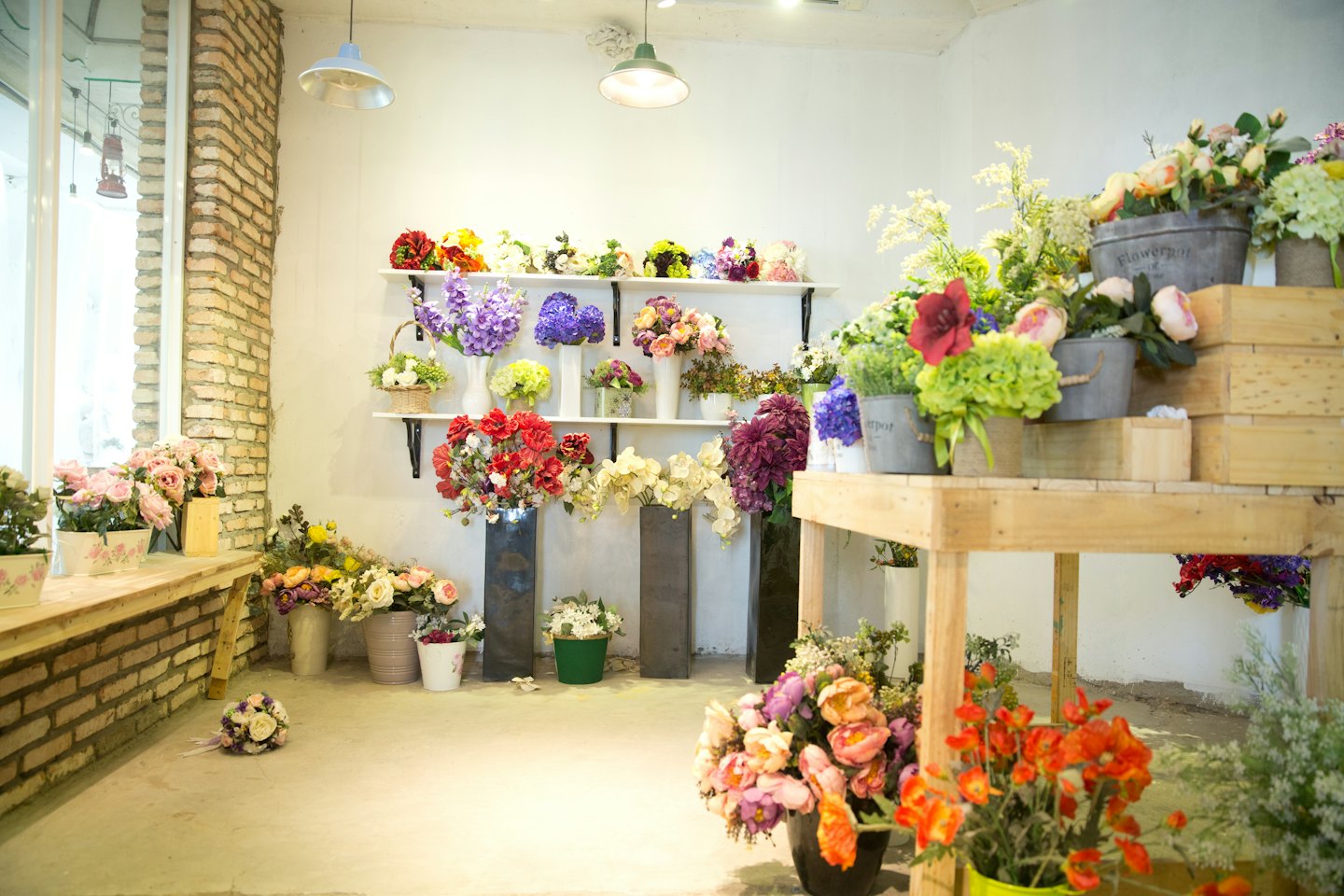 Colorful artificial flowers displayed in a bright flower shop.