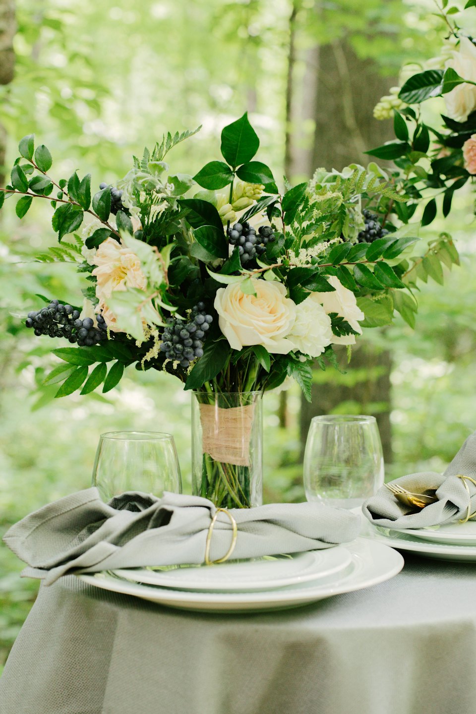 Outdoor table set with floral centerpiece and place settings.